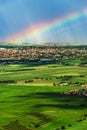 Colorful rainbow over the green fields and vineyards