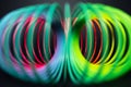Colorful rainbow spiral toy on black background. Close-up view. Royalty Free Stock Photo