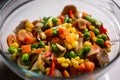 colorful raw food in glass bowl made from carrot, bean, peas, red pepper and corn Royalty Free Stock Photo