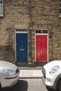 Colorful red and blue doors on a facade of a typical British terrace house