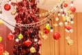 Colorful red, gold, green and silver Hanging Glittering ball baubles background with decorated red Christmas Tree in shopping mall