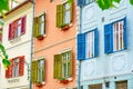 Colorful red, green, and blue wooden shutters on white windows, in bright day. Three buildings side by side in Sibiu, Romania Royalty Free Stock Photo