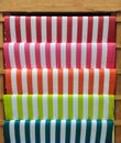 Colorful Red, Pink, Orange, Green and Blue Stripe Pattern Paper on Wooden Shelf for DIY Work