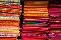 colorful red, purple, pink, yellow, blue, green and orange textile fabrics for sale in a shop Royalty Free Stock Photo