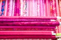 colorful red, purple, pink, yellow, blue, green and orange textile fabrics for sale in a shop Royalty Free Stock Photo