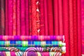 colorful red, purple, pink, yellow, blue, green and orange textile fabrics for sale in a shop Royalty Free Stock Photo