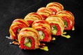 Colorful red rice uramaki rolls with shrimp tempura, salmon and sauces Royalty Free Stock Photo