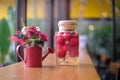 Colorful red rose flower in watering pot and cherries in glass Royalty Free Stock Photo