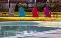 Colorful relaxing Lounge chairs along a swimming pool on a sunny day quarantine isolation concept.