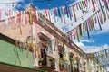 Colorful ribbons strung across an aging pink building against a blue sky in Campeche