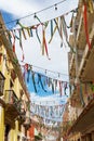 Colorful ribbons strung zigzag between buildings in Campeche, Mexico - vertical