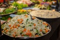 Colorful rice in the foreground with defocused restaurant food buffet in the background Royalty Free Stock Photo