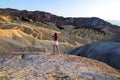 Colorful Ridges landscape with standing attractive young woman open arms wide to feel free, young girl traveler at Death Valley US Royalty Free Stock Photo