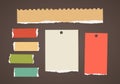 Colorful ripped blank note paper are stuck on dark brown background