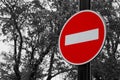 Colorful road traffic sign Entry is prohibited on back and white background of sky aqnd trees foliage. Sign is also known as ``T Royalty Free Stock Photo