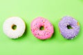 Colorful round donuts on green background. Flat lay, top view. Royalty Free Stock Photo