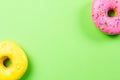 Colorful round donuts on green background. Flat lay, top view. Royalty Free Stock Photo