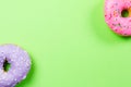 Colorful round donuts on green background. Flat lay, top view. Royalty Free Stock Photo