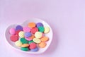 Multicolored candy melts in the heart shaped plate Royalty Free Stock Photo