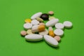 Colorful pills and capsules on a green background Royalty Free Stock Photo