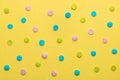 Colorful round sprinkles over yellow background, decoration for festive Valentines day, birthday, holiday and party time