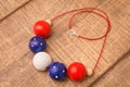 Colorful round wood beads necklace hand painted with blue, red, white and natural color beads on a wood table Royalty Free Stock Photo