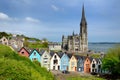 Colorful row houses with St. Colman`s Cathedral in background in the port town of Cobh, County Cork, Ireland Royalty Free Stock Photo