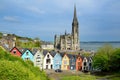 Colorful row houses with towering St. Colman`s Cathedral in background in the port town of Cobh, Ireland Royalty Free Stock Photo