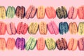 Colorful rows of macarons on vintage pink background