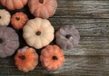 Eight rustic pumpkins diffent colors on a rustic wooden background.