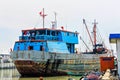 Colorful rusty ship in Jakarta harbor with fishermen on board