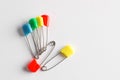 Colorful safety pins on white background, flat lay. Space for text Royalty Free Stock Photo