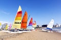 Colorful sail boats against blue city skyline