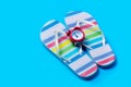 Colorful sandals and cute small alarm clock on the wonderful blu