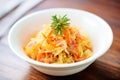 colorful sauerkraut with carrot strips, in white bowl