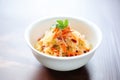 colorful sauerkraut with carrot strips, in white bowl