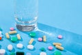 Colorful scattered tablets, water glass, blister with medical pills, multivitamins Royalty Free Stock Photo