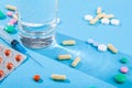 Colorful scattered tablets, water glass, blister with medical pills, multivitamins