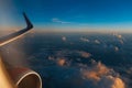 Colorful scenic view of beautiful sunrise, cloudy sky and airplane wing with engine, through window of the aircraft. Royalty Free Stock Photo