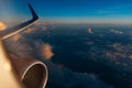 Colorful scenic view of beautiful sunset, cloudy sky and airplane wing with engine, through window of the aircraft during the Royalty Free Stock Photo