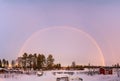 Colorful Scenic Winter Rainbow over winter snowy landscape, full size, double arch, second one not so strong. Pink frosty sky