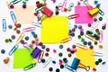 Colorful school and office supplies paper clips, pins, yellow notes, stickers on white background