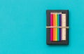 Colorful school and office supplies - pencils and ruler on black book and blue background. Top view with copy space Royalty Free Stock Photo
