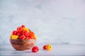 Colorful scotch bonnet chili peppers in wooden bowl over grey background. Copy space. Royalty Free Stock Photo