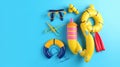 Colorful scuba stuff and beach accessories like umbrella, flip flops and inflatable ring on blue Royalty Free Stock Photo