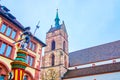 The sculpture of Sevogelbrunnen and stone bell tower of Martin`s Church in Basel, Switzerland