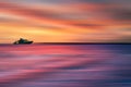 Colorful sea front view sunset with yacht at the horizon line, motion blur effect with clods and wave. Vacation time to relax and Royalty Free Stock Photo