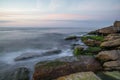 Colorful sea shore with green algae long exposure water at sunset time Royalty Free Stock Photo