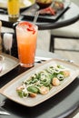 Colorful seafood salad with scallop and squid and cold orange cocktail on the table at restaurant