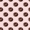 Colorful seamless pattern of chocolate donuts with light pink background. Sweetness pastel colors. Confectionery banner Royalty Free Stock Photo